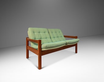 May include: A light green two-seater sofa with a tufted back and seat cushions. The sofa is made of teak wood and has a simple, mid-century modern design.