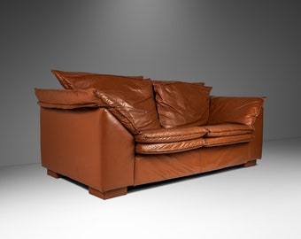 May include: A brown leather two-seater sofa with a tufted design and a slightly distressed look.