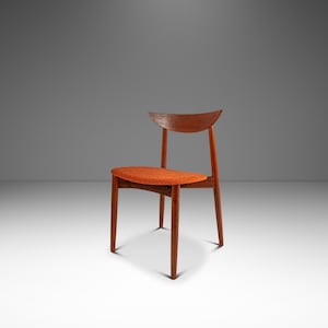 May include: A mid-century modern chair with a curved wooden back and legs. The seat is upholstered in orange fabric. The chair is made of wood and has a minimalist design.