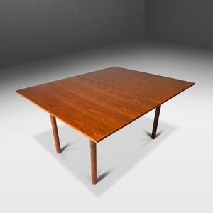 May include: A rectangular wooden table with a drop leaf extension. The table has four legs and is made of a rich brown wood.