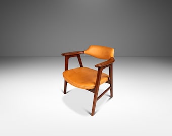 Op de afbeelding: Een moderne fauteuil uit het midden van de eeuw met een bruine leren zitting en een donkerhouten frame.