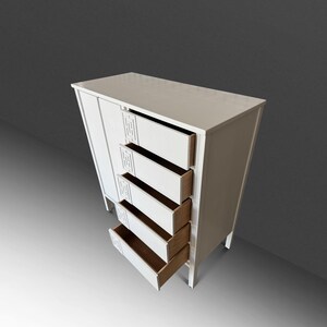 May include: A white wooden cabinet with four open drawers and a closed door. The cabinet has a rectangular shape and is elevated on short legs. The drawers are open, revealing a light brown interior. Decorative cutouts are on the cabinet's front.