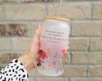 May include: A frosted glass water bottle with a bamboo lid and a floral design. The bottle has a quote on it that reads "His mercies are new every morning. Great is Thy faithfulness. Lamentations 3:23"