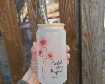 May include: White frosted tumbler with a bamboo lid and a stainless steel straw. The tumbler has a floral design and the text "Created with a Purpose. Ephesians 2:10"