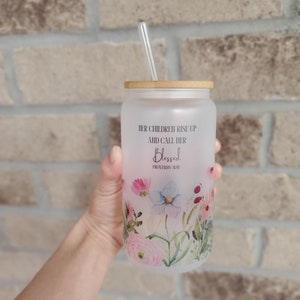 May include: A frosted glass tumbler with a bamboo lid and a straw. The tumbler has a floral design and the text "Her children rise up and call her blessed, Proverbs 31:28".