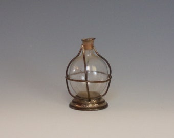 Tiny Antique Novelty Clear Blown Glass Bottle w Cork Remnants & Wire Frame Welded into Metal Pedestal Base Marked Pat April 25 1882.vLua