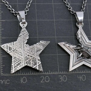 May include: Two silver star-shaped pendants on chains. One pendant is solid with a geometric pattern, the other has a beetle design inside the star.