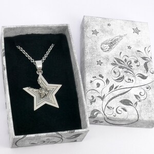 May include: A silver necklace with a multi-layered star pendant in a gray and white patterned gift box.