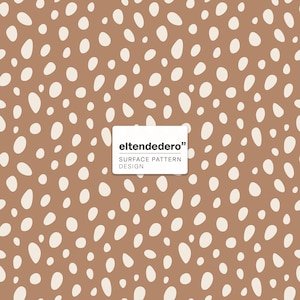 May include: A repeating surface pattern design featuring irregular off-white oval shapes scattered across a solid brown background. A white rectangular label in the center displays the black text eltendedero SURFACE PATTERN DESIGN.