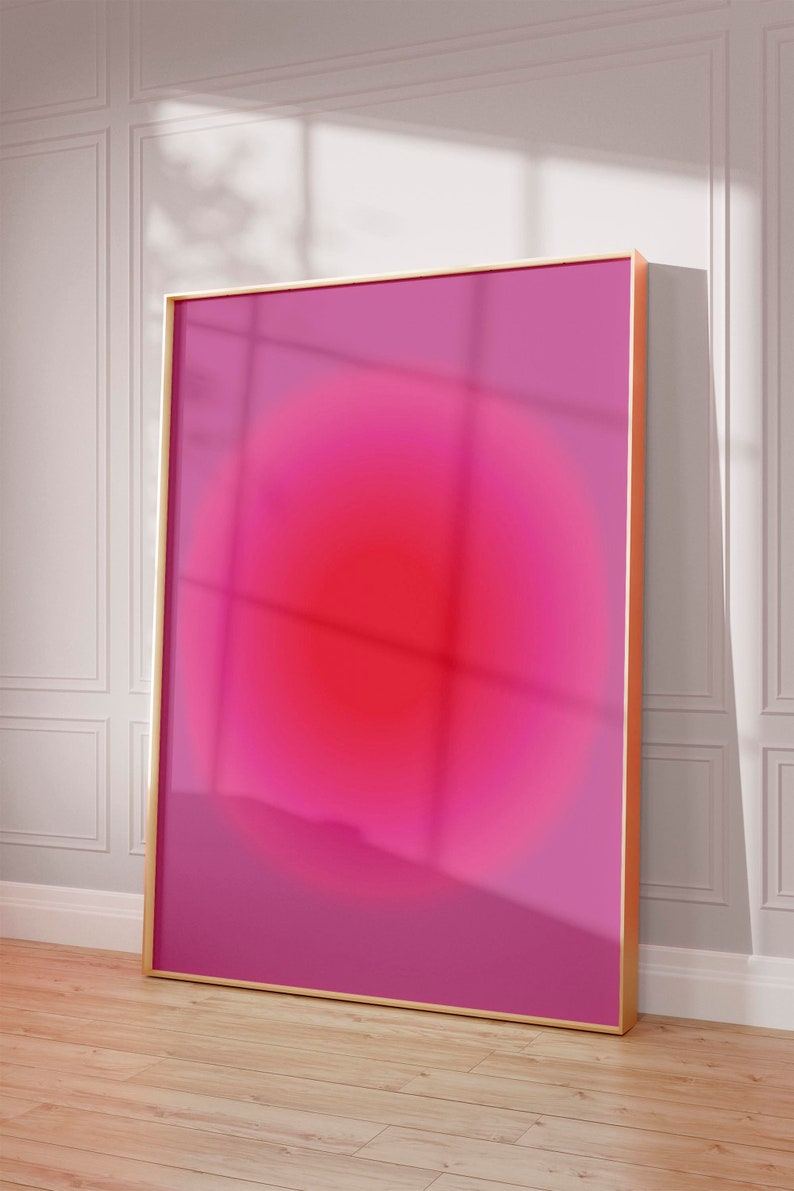 May include: A framed abstract art print with a pink and red gradient circle in the center. The frame is gold.