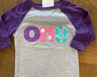 One birthday applique purple sleeve raglan, purple, pink and teal letters