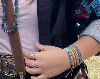 Pulsera tipo brazalete de cuero turquesa con núcleo flexible de latón ajustable.