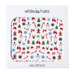 May include: A sheet of white nail decals with a Christmas theme. The decals feature a variety of festive designs, including snowmen, reindeer, candy canes, gingerbread men, snowflakes, bows, and Christmas trees. The decals are perfect for adding a touch of holiday cheer to your nails.