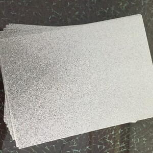 May include: A stack of white frosted acrylic sheets with a textured surface.