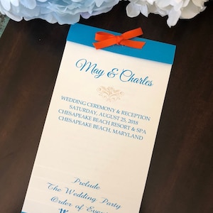 May include: A wedding ceremony and reception order of events card with a blue and white design. The card features the names "May & Charles" and the date "Saturday, August 25, 2018".