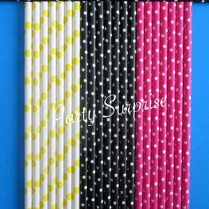 May include: A collection of colorful paper straws with polka dot patterns in yellow, black, and pink. The straws are arranged vertically against a blue background, with the text "Party Surprise" in white.