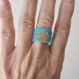 May include: A white ceramic mug with a black handle and the text "But First, Coffee" in a black, bold font. The mug is on a white surface.