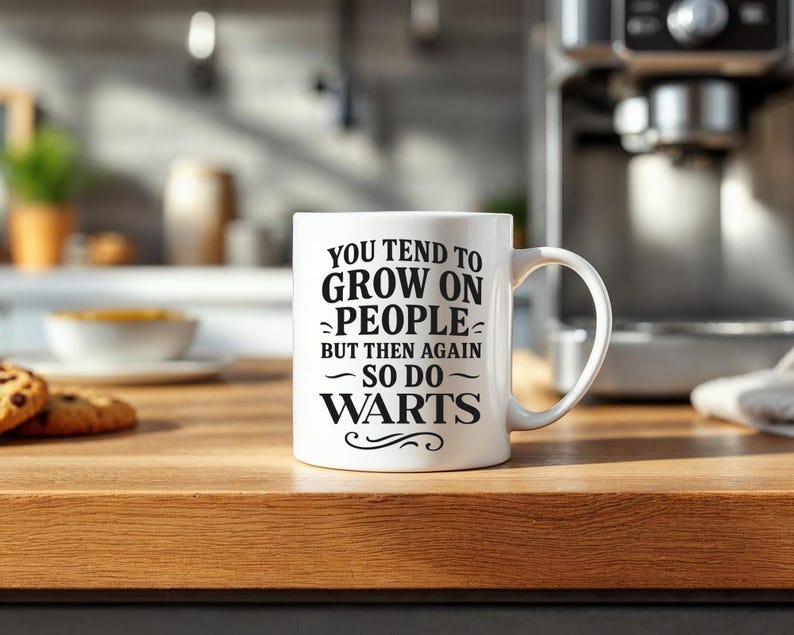 May include: White ceramic coffee mug with black text that reads "You tend to grow on people but then again so do warts".