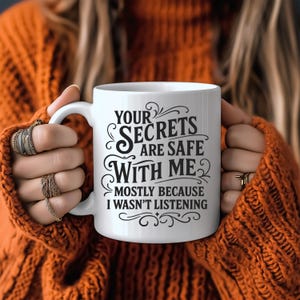May include: White ceramic mug with black text that reads "Your Secrets Are Safe With Me. Mostly Because I Wasn't Listening."