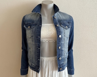 May include: A blue denim jacket with a light wash on the front and a darker wash on the sleeves. The jacket has a button closure and two pockets on the front.