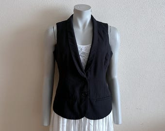 May include: A black pinstripe sleeveless vest with a collar and a single button closure.