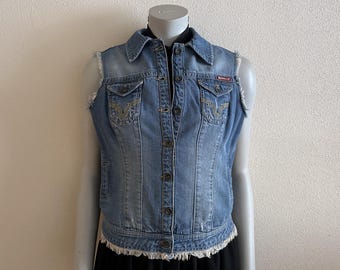 May include: Light blue denim vest with a collared neckline, button-up front, and frayed edges. Features two front pockets with decorative stitching and a small red logo patch. A classic, casual outerwear piece.