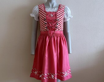 May include: A pink and white dirndl dress with a red and white gingham bodice and white trim. The dress has a white lace overlay and a heart-shaped design on the bodice.