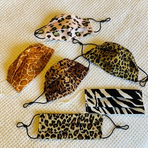 May include: Six different patterned face masks with adjustable ear loops. The masks are made of fabric and feature various animal prints, including leopard, giraffe, and zebra.