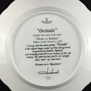 Peut inclure: Une assiette en porcelaine blanche avec une image en noir et blanc d'une orchid&eacute;e. L'assiette fait partie d'une s&eacute;rie en &eacute;dition limit&eacute;e intitul&eacute;e "Orchidee" et "Fleurs et Rubans". L'assiette est sign&eacute;e par le directeur de la manufacture.