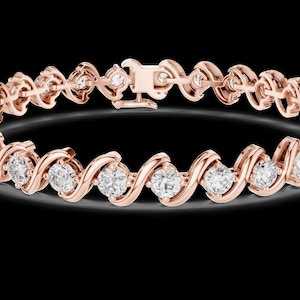 May include: Rose gold bracelet featuring a series of sparkling round-cut diamonds set in a wave-like pattern. The bracelet has a secure clasp and is displayed against a black background, highlighting its brilliance.