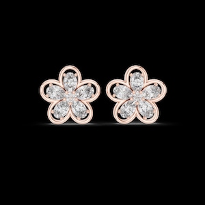May include: A pair of rose gold stud earrings shaped like five-petaled flowers. Each earring features five marquise-cut clear stones arranged as petals within a rose gold frame, with a small round clear stone at the center of each floral design.
