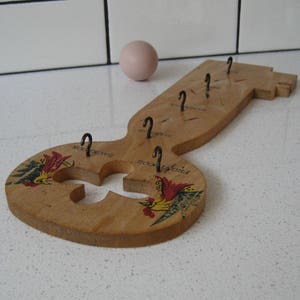 May include: Wooden key-shaped key holder with five hooks and a rooster design. The key holder is painted with red, yellow, and green colors.