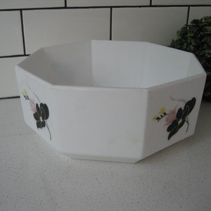 May include: White octagonal serving bowl with black and pink floral designs. The bowl is made of ceramic and has a glossy finish.