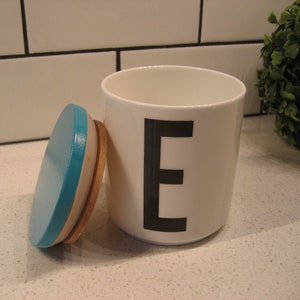 Recipiente de almacenamiento con diseño de letras de Arne Jacobsen vintage, taza de porcelana, tipografía, tapa de madera color aguamarina, Barrio Sésamo, presentado por The Letter E