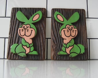 Juego de 2 placas de pared de tiza de 7" con diseño de conejos del bosque vintage, estilo Thing 1 Thing, conejos verdes. Copyright 1972 Miller Studio. Textura de pared de galería.
