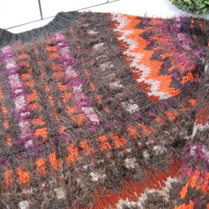 May include: A brown, orange, purple, and gray fuzzy knit sweater with a geometric pattern.
