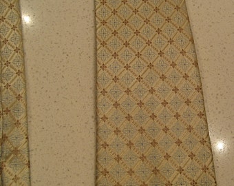 May include: A gold tie with a brown and blue geometric pattern.