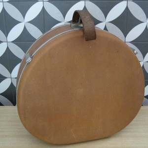 May include: A brown leather vintage suitcase with a metal handle and a silver latch.