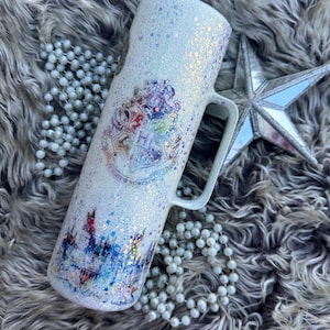Può includere: Tazza in ceramica bianca con finitura glitter e un design con lo stemma della casa di Hogwarts. La tazza presenta un'immagine in stile acquerello del castello di Hogwarts.