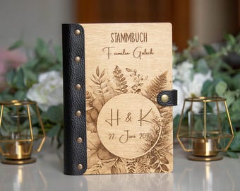 May include: A wooden Stammbuch, or family record book, with a black leather spine and clasp. The cover features engraved botanical designs and a circular emblem with initials and a date. The text reads "STAMMBUCH Familie Gulich" and "H & K 27 June 2025".