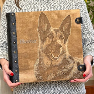 Puede incluir: Un &aacute;lbum de fotos de madera marr&oacute;n con una encuadernaci&oacute;n de cuero negro y detalles met&aacute;licos. El &aacute;lbum presenta una imagen grabada con l&aacute;ser de un pastor alem&aacute;n con el nombre "Hunter" grabado en la parte delantera.