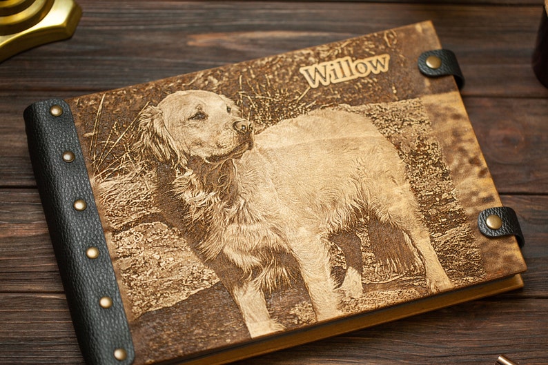 Puede incluir: Un &aacute;lbum de fotos encuadernado en cuero marr&oacute;n con lomo de cuero negro y remaches met&aacute;licos. La portada presenta una imagen grabada con l&aacute;ser de un perro golden retriever con el nombre "Willow" grabado sobre la imagen.