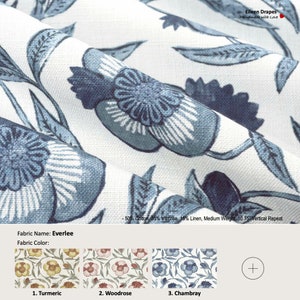 May include: A close-up of a white fabric with a blue floral pattern. The fabric is called "Everlee" and is available in three colors: Turmeric, Woodrose, and Chambray. The fabric is 50% cotton, 35% viscose, and 16% linen. It has a medium weight and a 10.75-inch vertical repeat.