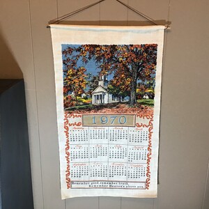 May include: A vintage 1970 calendar tea towel with a church and fall foliage scene. The calendar features the months of the year and the quote "Remember good counsel, remember Heaven's truth above you."