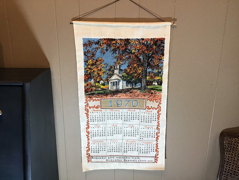 May include: A vintage 1970 calendar tea towel with a church and fall foliage scene. The calendar features the months of the year and the quote "Remember good counsel, remember Heaven's truth above you."