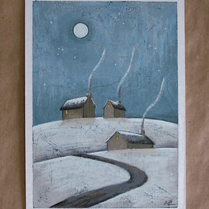 May include: A painting on a white rectangular background depicting a snowy landscape at night with three small houses. Each house has a glowing yellow window and a chimney emitting white smoke. A full moon shines in the blue sky above the hills.