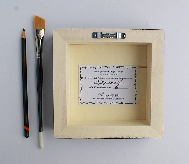 May include: The back of a framed painting with a white mat and a cream-colored backing. The backing has a label with the text "Art original de Original Art by Marie Claprood De la s&eacute;rie dad Variations - No. 6"x 6" Variations - No. 14 www.MarieClaproodArt.etsy.com".