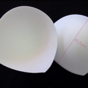 Könnte beinhalten: Zwei weiße Schaumstoff-BH-Cups, jeder mit einem Durchmesser von 17,5 cm.