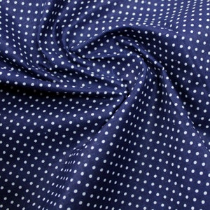 Può includere: Tessuto blu navy con motivo a pois bianchi. Il tessuto è raccolto e piegato, creando un aspetto strutturato. I pois bianchi sono uniformemente distanziati sulla superficie, offrendo un design classico e versatile.