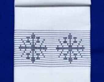 May include: White kitchen towel with a blue embroidered snowflake design.